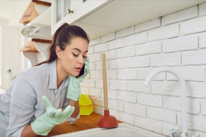 A woman is trying to find out how to unclog a kitchen sink